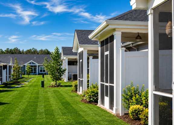 A row of houses with white siding and large windows.