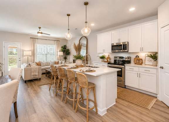 A kitchen with a white island and wooden floors.