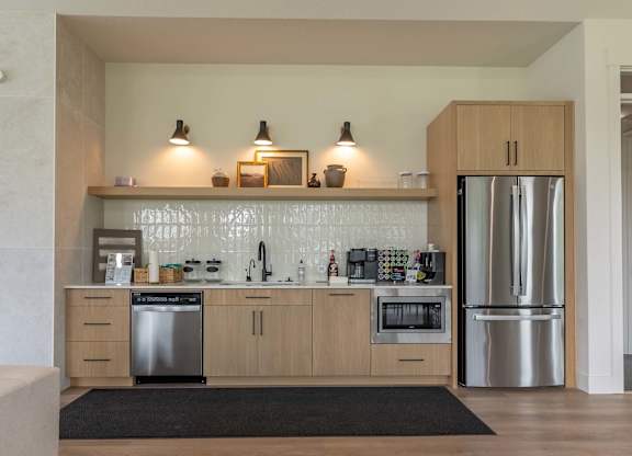 A modern kitchen with wooden cabinets and stainless steel appliances at Marcola Apartment Homes, Forest Grove
