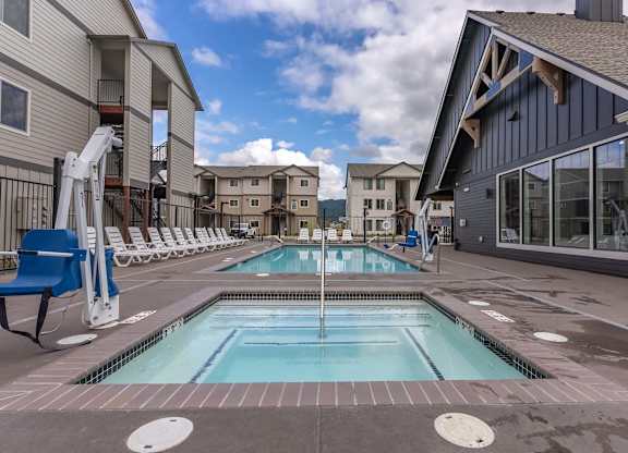 A swimming pool in a residential area with a blue chair at Marcola Apartment Homes, Forest Grove, 97477