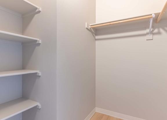 A white shelving unit with three shelves is mounted on a wall at Marcola Apartment Homes, Forest Grove, OR