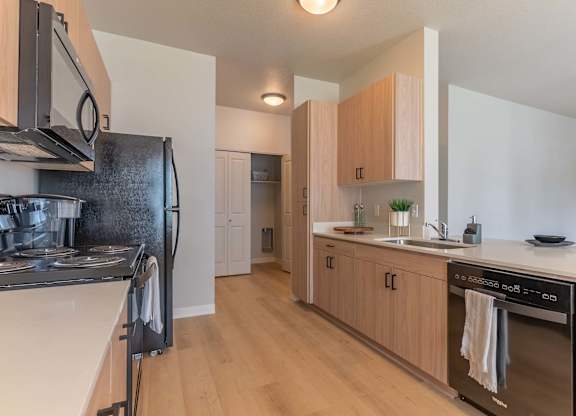 A kitchen with wooden cabinets and a black stove top oven at Marcola Apartment Homes, Forest Grove, 97477