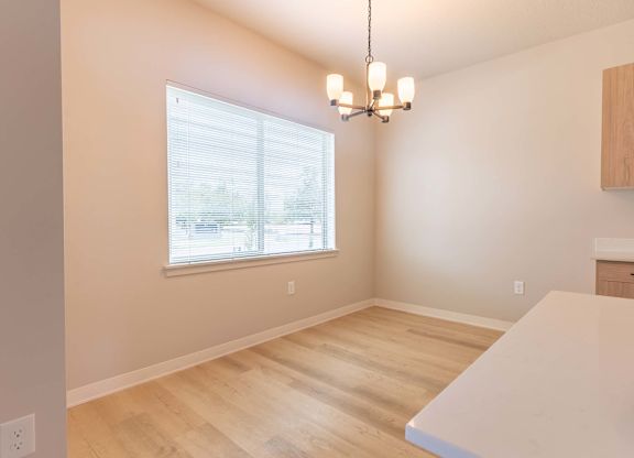 A room with a window and a chandelier at Marcola Apartment Homes, Forest Grove