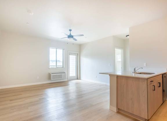 A kitchen area with a sink, a window, and a fan at Marcola Apartment Homes, Forest Grove, OR, 97477