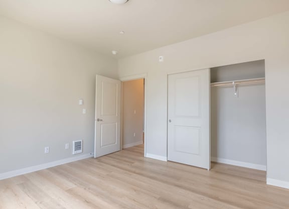 A room with two doors and a wooden floor at Marcola Apartment Homes, Forest Grove