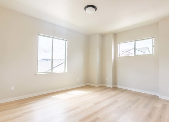 A room with wooden floors and two windows at Marcola Apartment Homes, Forest Grove, OR