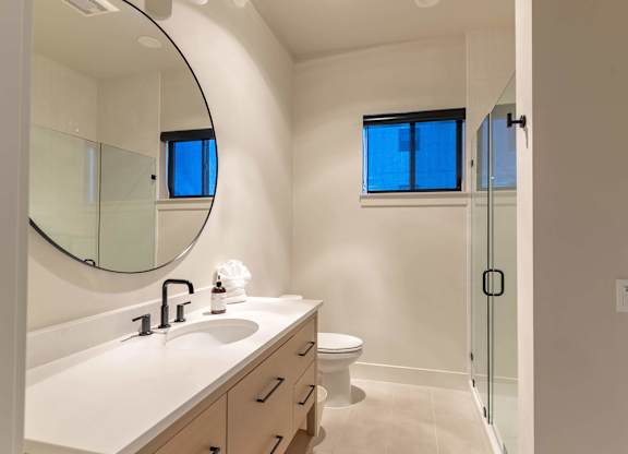 A bathroom with a sink, mirror, toilet and shower at Westgate Apartment Homes, Oregon