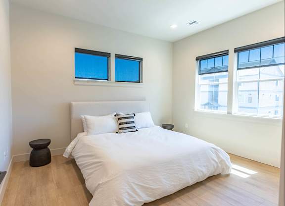 A bedroom with a large bed and two windows at Westgate Apartment Homes, Pendleton, 97801