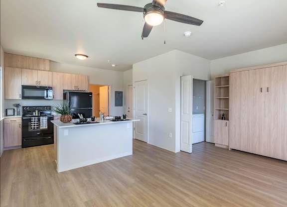 A kitchen with a white island and wooden floors at Westgate Apartment Homes, Oregon, 97801
