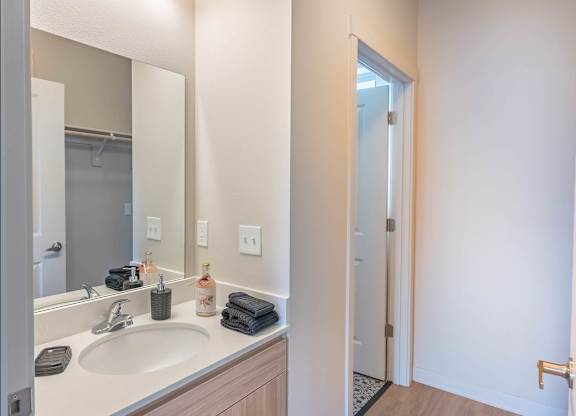A bathroom with a sink, mirror, and towel at Westgate Apartment Homes, Pendleton, Oregon