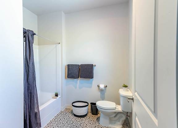 A bathroom with a toilet, a bathtub, and a towel rack at Westgate Apartment Homes, Oregon, 97801