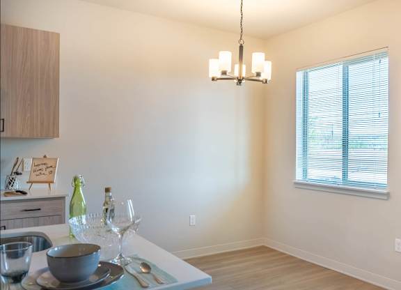 A dining table with a bowl, a bottle, and a glass on it at Westgate Apartment Homes, Pendleton, OR, 97801