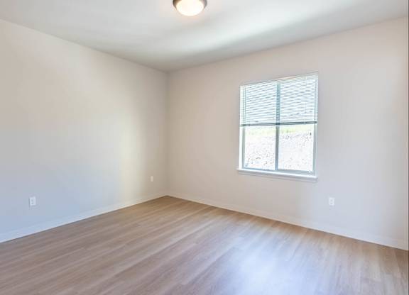 A room with a window and wooden flooring at Westgate Apartment Homes, Pendleton