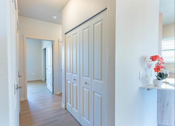 A hallway with white doors and a mirror on the wall at Westgate Apartment Homes, Pendleton