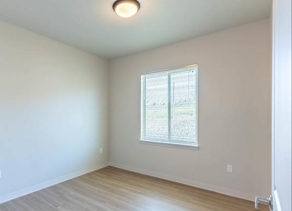 A room with a window and wooden flooring at Westgate Apartment Homes, Pendleton, OR