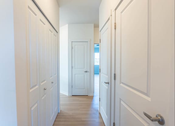 A long hallway with white doors and a wooden floor at Westgate Apartment Homes, Oregon, 97801