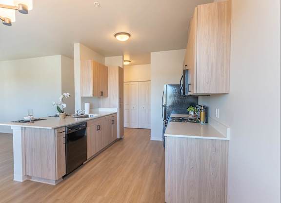A kitchen with wooden cabinets and a white counter top at Westgate Apartment Homes, Pendleton, Oregon