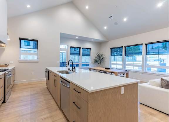 A modern kitchen with wooden cabinets and a large island at Westgate Apartment Homes, Oregon, 97801