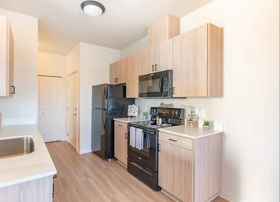 A kitchen with wooden cabinets and black appliances at Westgate Apartment Homes, Pendleton, 97801