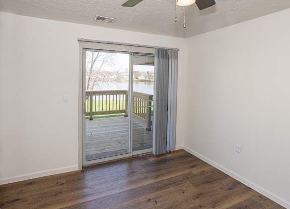 A room with a sliding glass door leading to a deck.