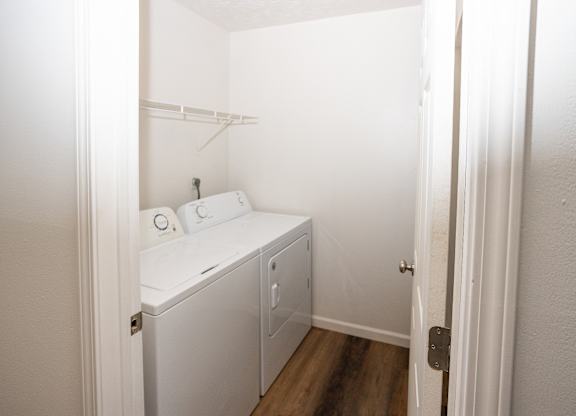 A small white laundry room with a washer and dryer.