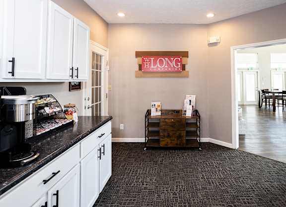 A kitchen with a black counter top and white cabinets.