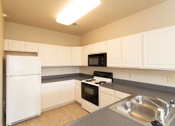 A kitchen with white appliances and cabinets.