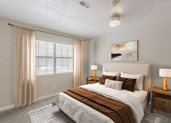 A bedroom with a large bed, a nightstand, and a window with curtains.