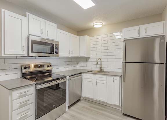 A kitchen with white cabinets and stainless steel appliances.
