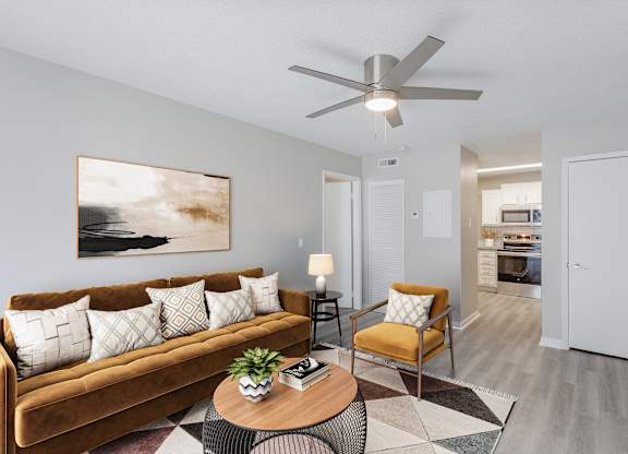 A living room with a brown couch, a coffee table, and a painting on the wall.