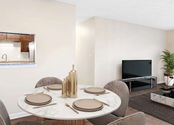 A dining table set with plates and cutlery is in the foreground of a modern dining room.