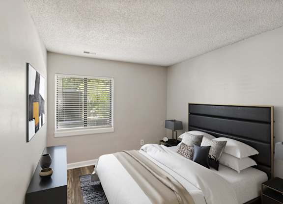 A bedroom with a large bed and a painting on the wall.
