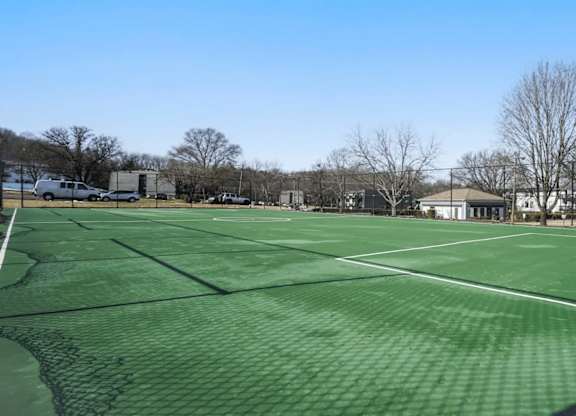 A tennis court with a green surface and white lines.