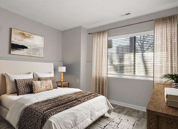 A bedroom with a large bed and a painting on the wall.