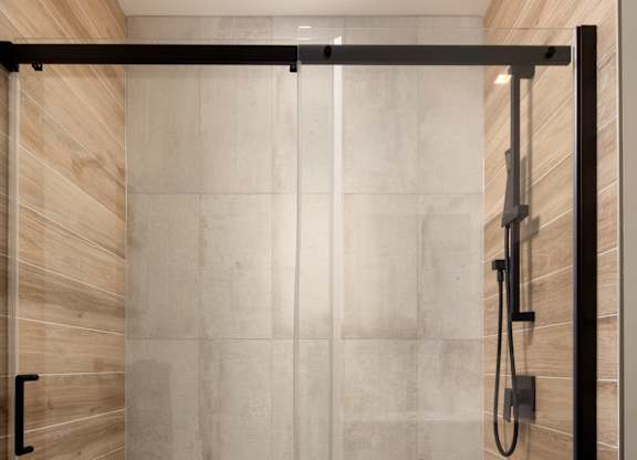 A modern bathroom with a walk-in shower.at Damask, Ontario