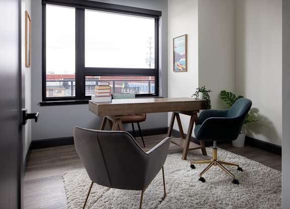 Large den featuring work desk and two chairs for home office at Damask, Windsor, ON
