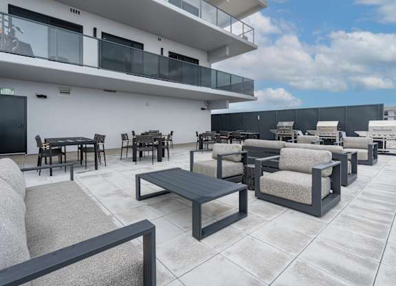 A patio with a table and chairs is in front of a white building at Damask, Windsor