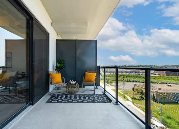 A balcony with a chair and a table with a plant on it at Damask, Ontario, N8S 0B7