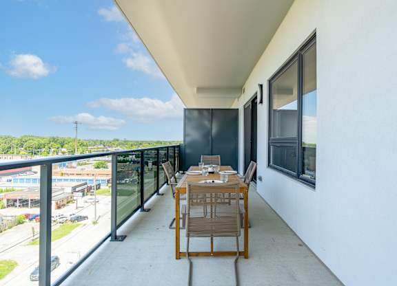 A balcony with a table and chairs overlooking a street at Damask, Ontario