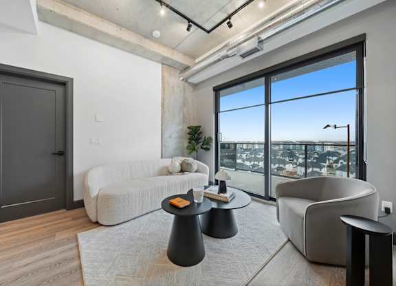A modern living room with a large window overlooking the city