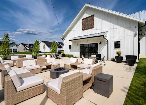 A white house with a patio furniture set in front.