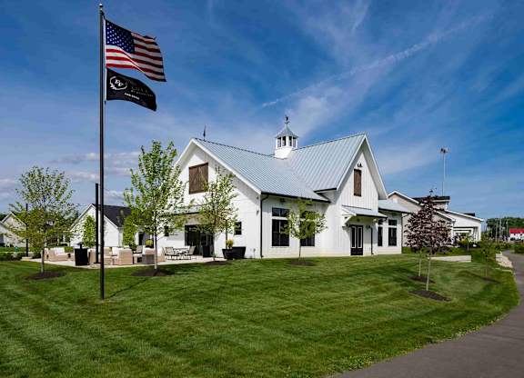 A white building with a black flagpole in front of it.