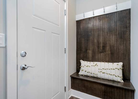 A white door with a silver handle and a white pillow with black lines on it.