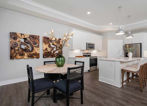 A modern kitchen with a dining table set for four.
