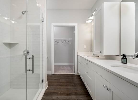 A white bathroom with a walk in shower.