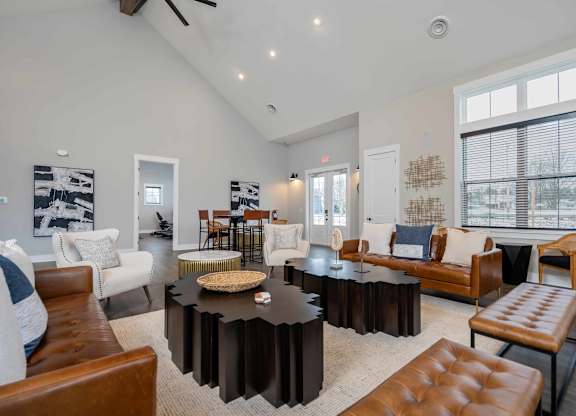 A living room with a black coffee table and brown leather chairs.