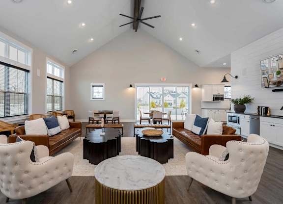 A modern living room with white furniture and a large window.