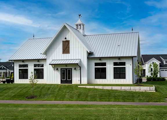 A white church with a black roof and a cross on top.