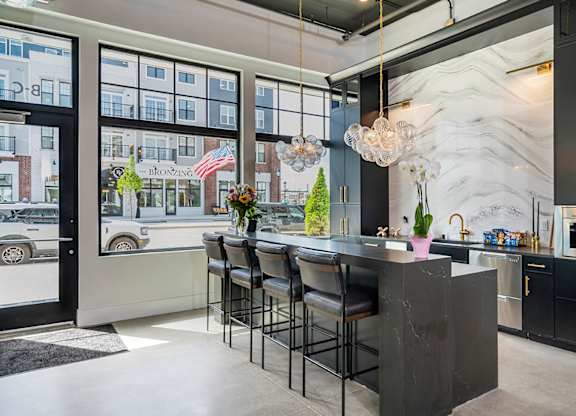 A kitchen with a marble backsplash and a bar area.