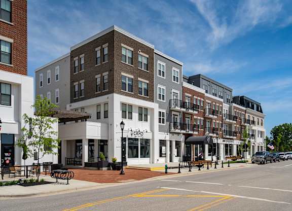 A street view of a row of buildings with a clear blue sky above.